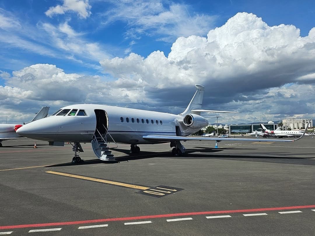 Falcon 2000 on the ramp under cumulus sky